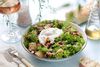 A bowl with salad lyonnaise in a bright setting.