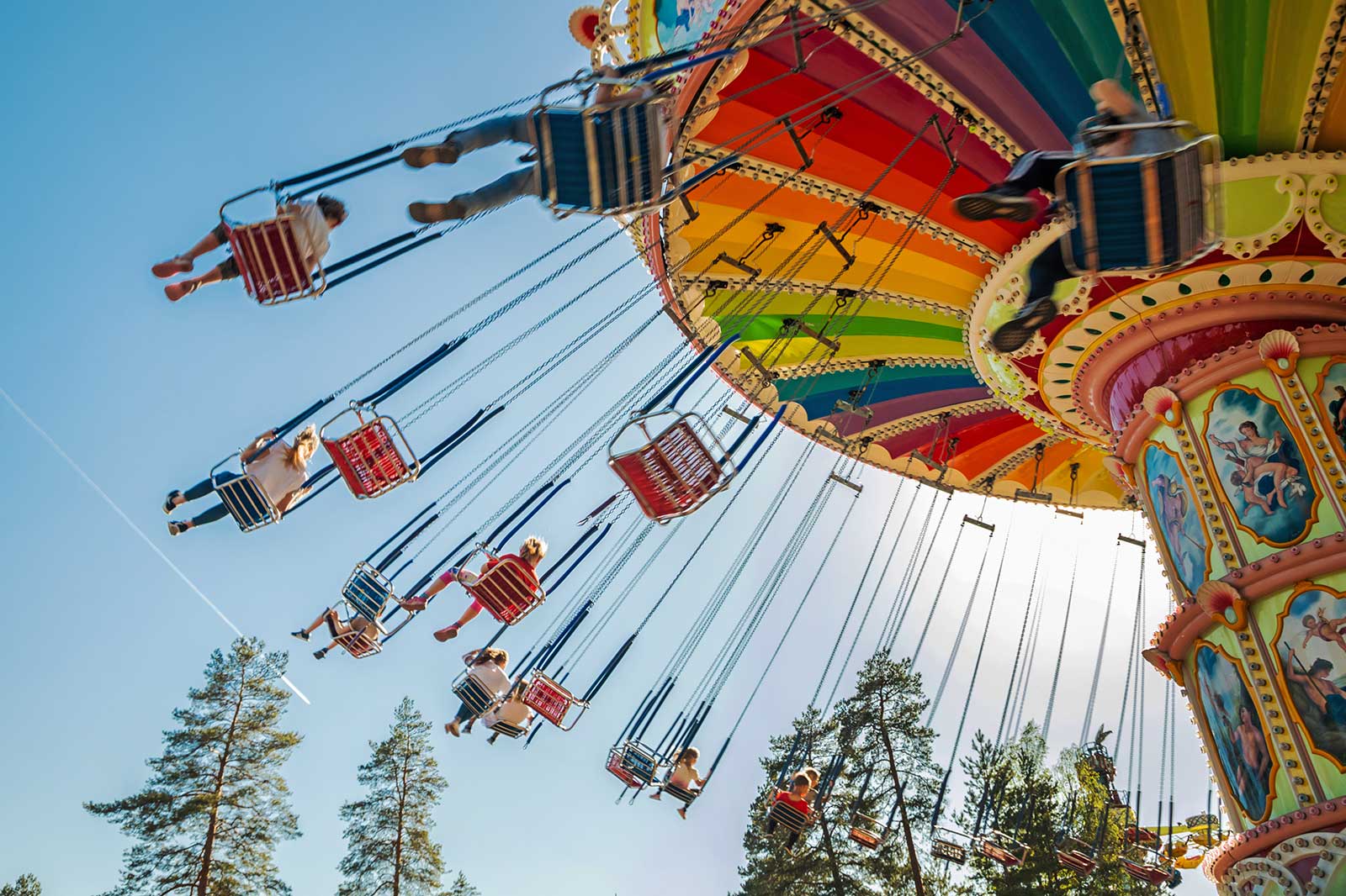 People riding a colourful carousel.