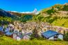 Traditional chalets and apartment buildings in Zermatt, Switzerland with the Matterhorn in the distance.