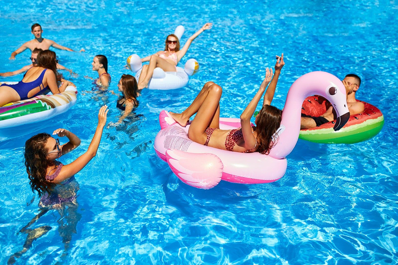 A group of people on pool floats in the water.