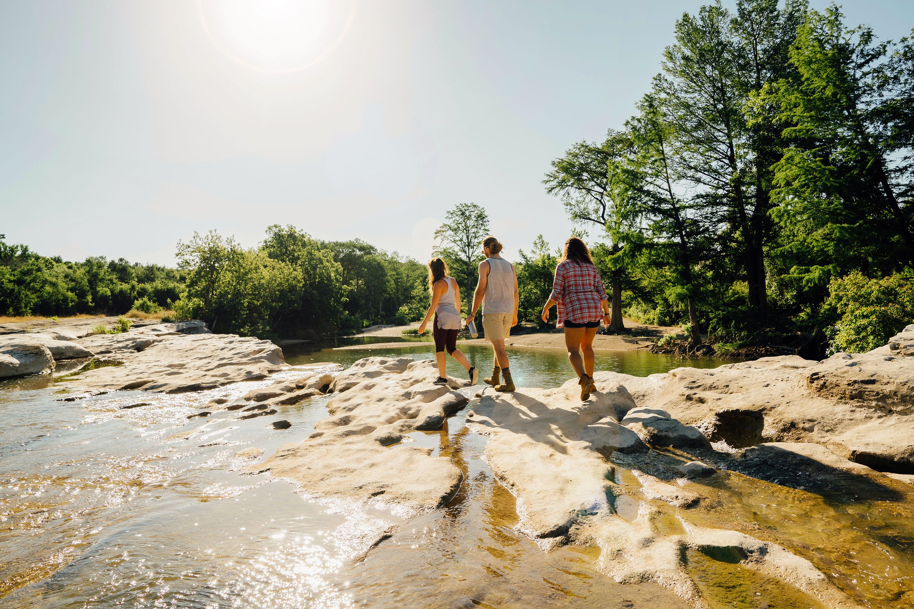 Hiking across rocks that cross a stream.