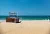 A volleyball net and a lifeguard hut on a beach.