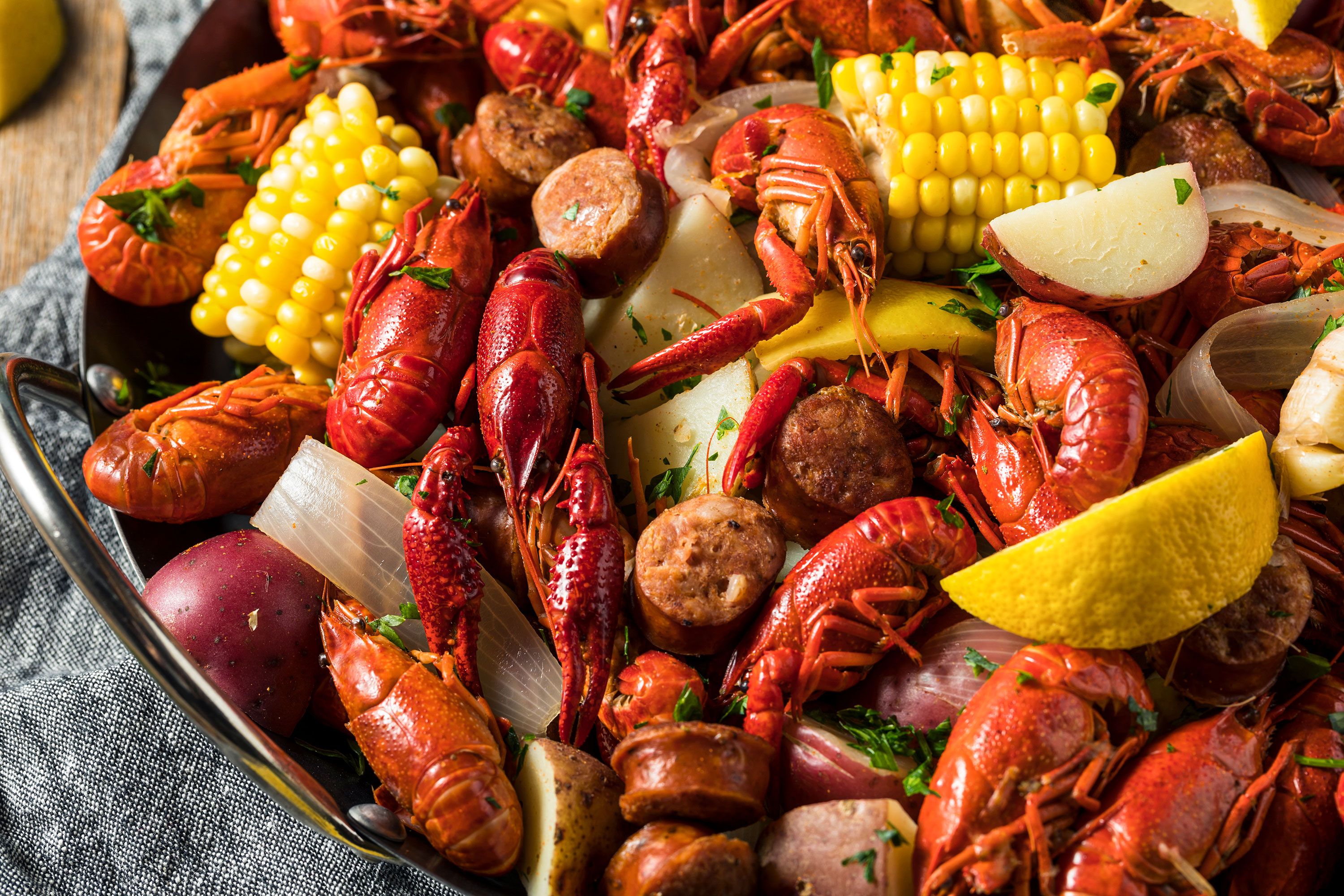 Close-up of steam pot boiling with crawfish corn sausage lemons and potatoes.