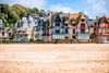 Colorful half-timbered houses by a beach.
