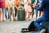 A musician plays on the street with a crowd.