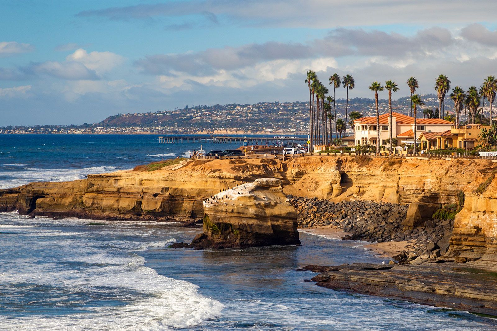 Orange sandy cliffs over the ocean.