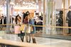 A group of people with shopping bags chatting in a mall.