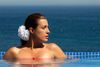 A woman relaxing in the pool overlooking the ocean.