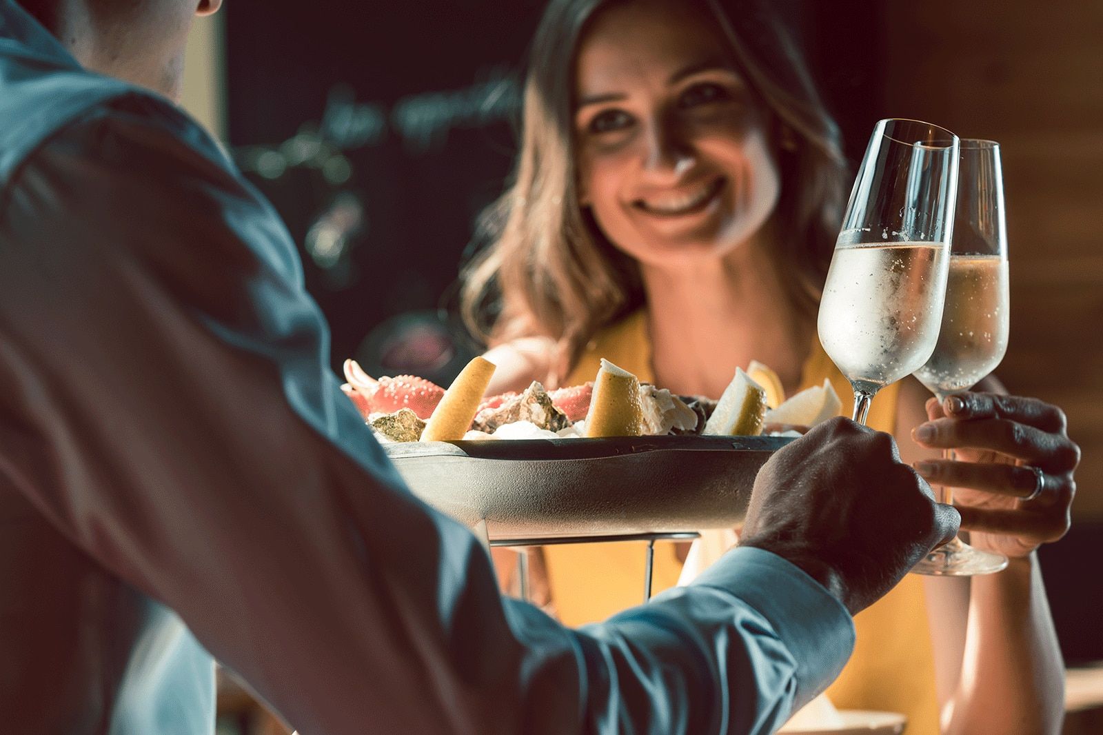 Smiling woman and a man toast glasses.