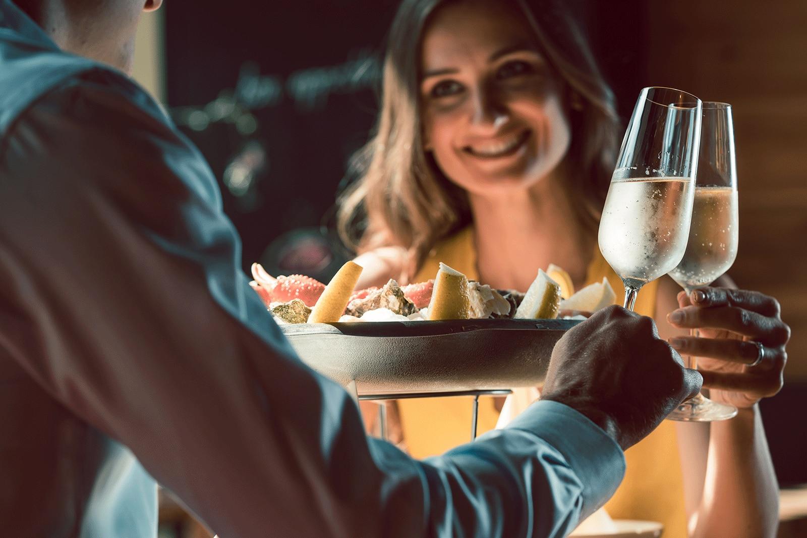 Smiling woman and a man toast glasses.
