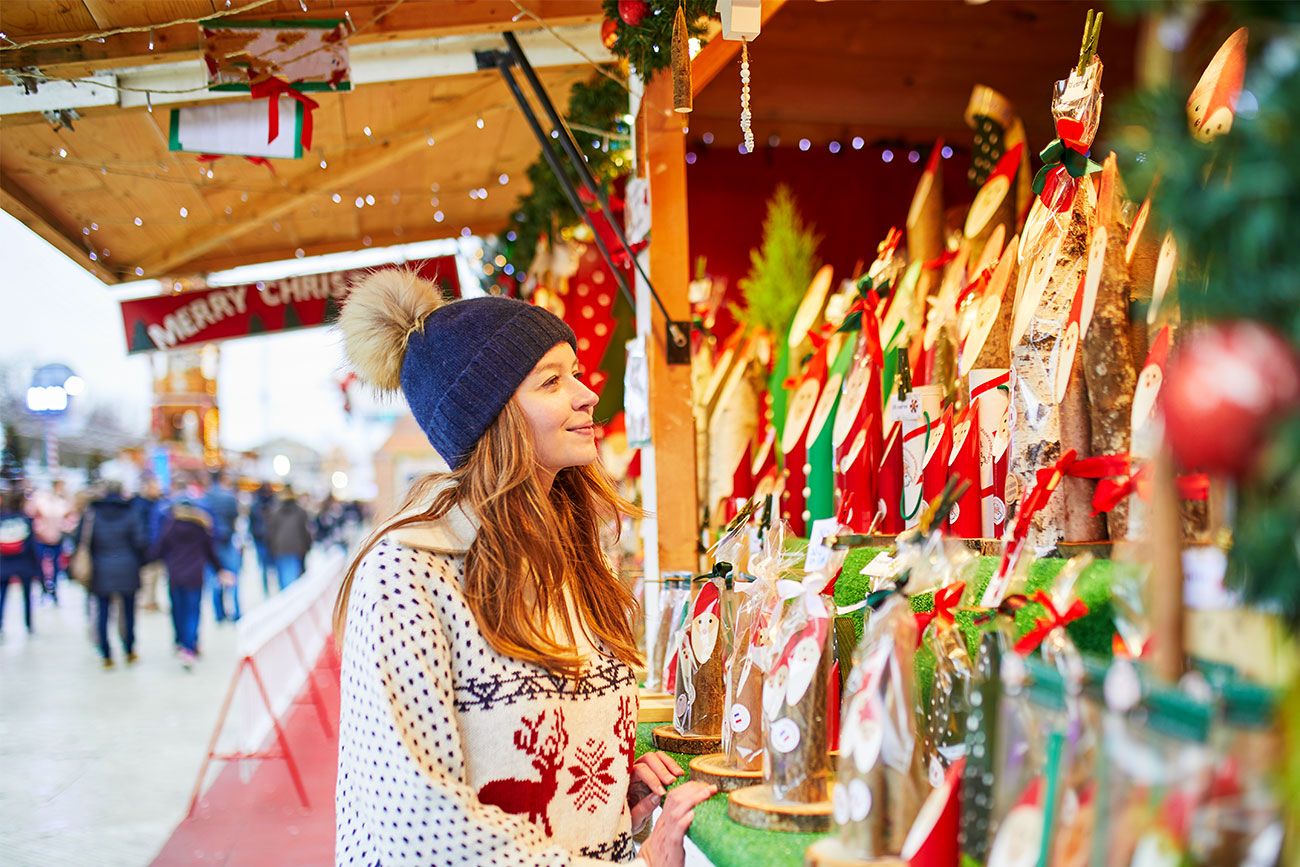 A woman buys holiday decorations on traditional Christmas market in Paris, France.