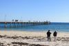 People looking at the pier over the water at Henley Beach.
