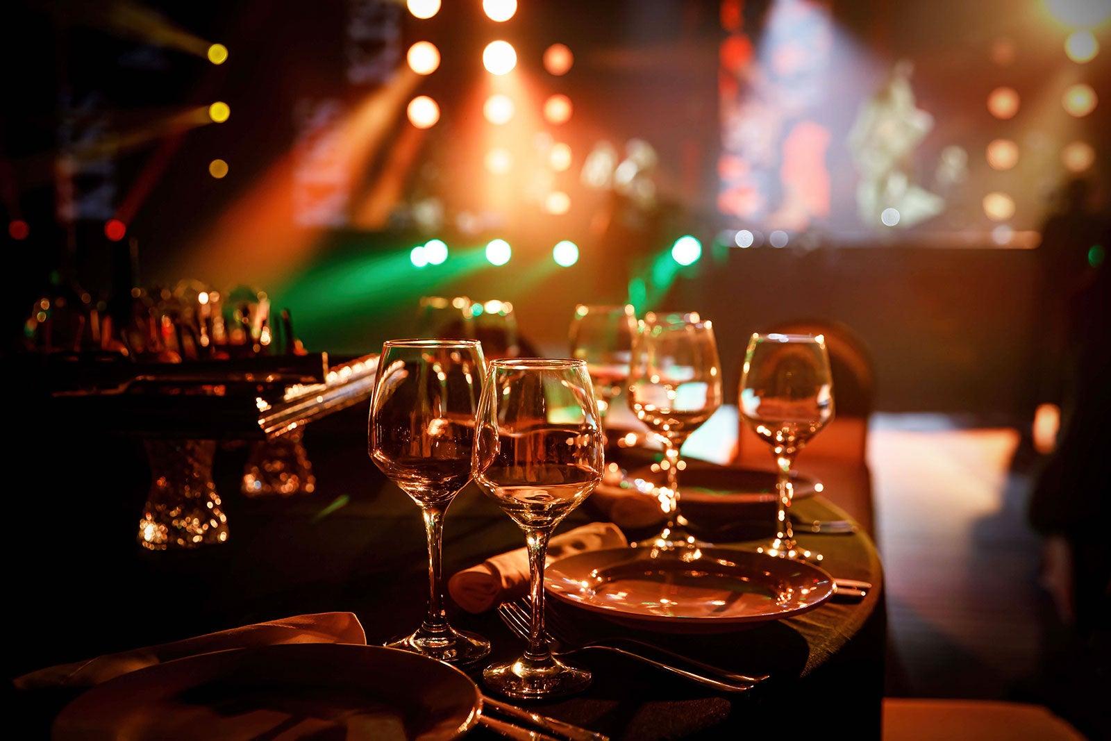 Glasses and table settings ready in front of a stage.