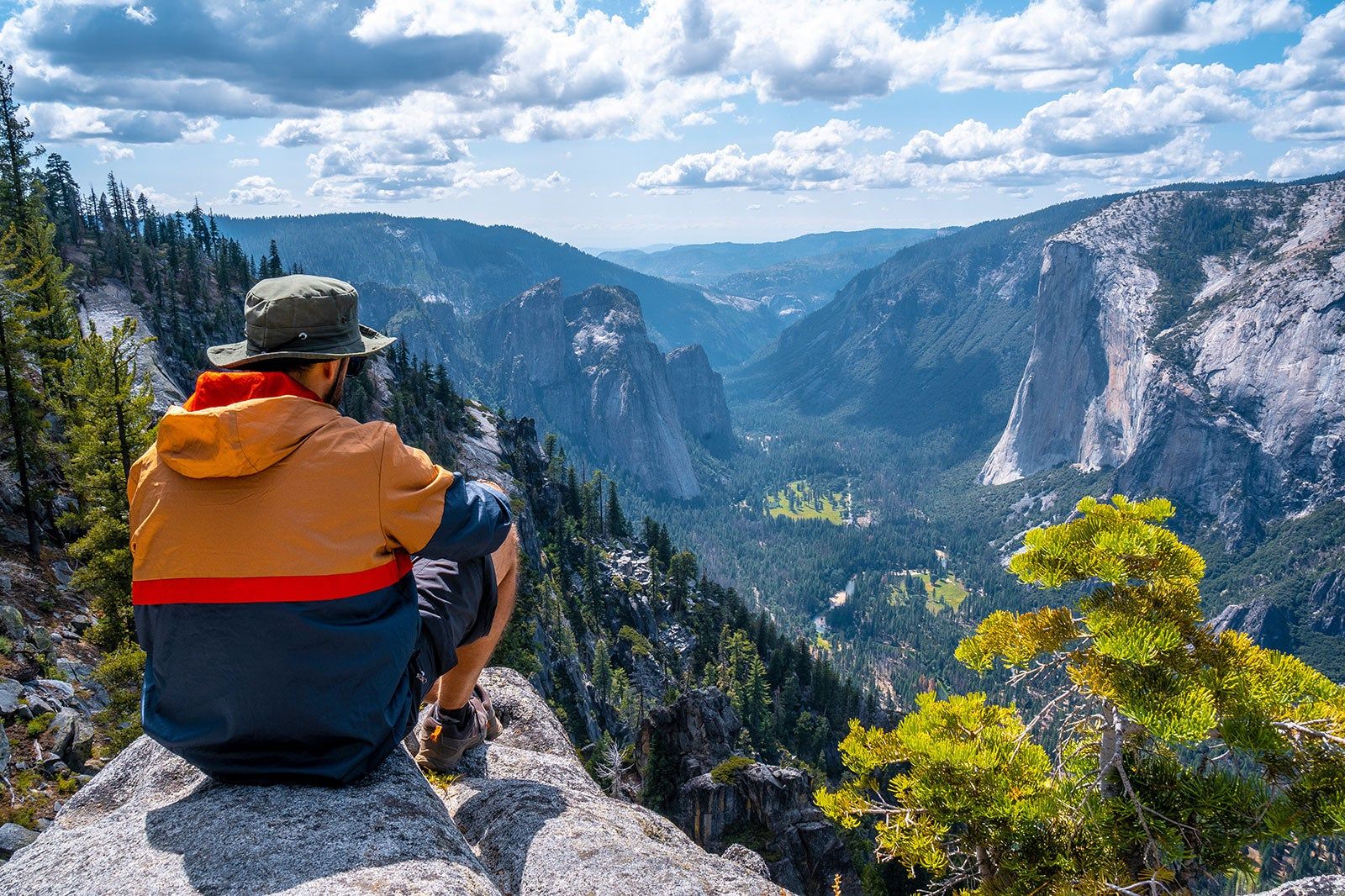 A man sits on a rock looking over Yosemite.
