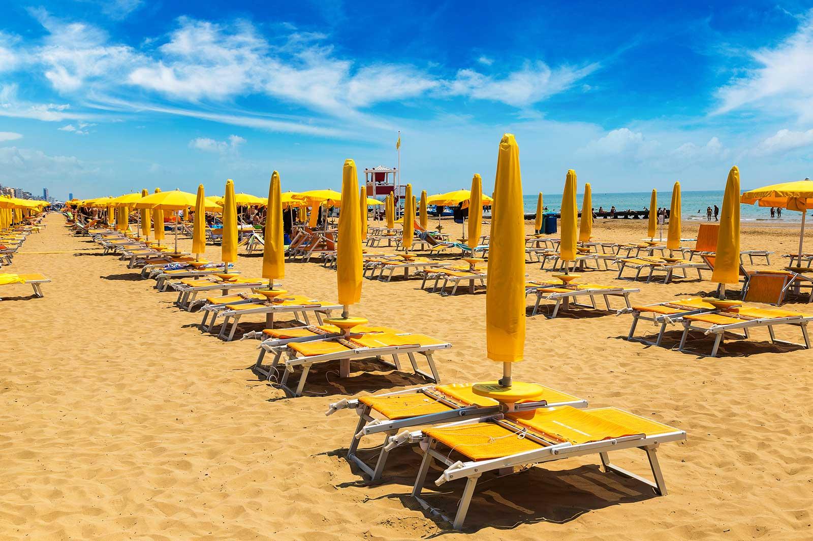 Beach with yellow beach chairs in rows.