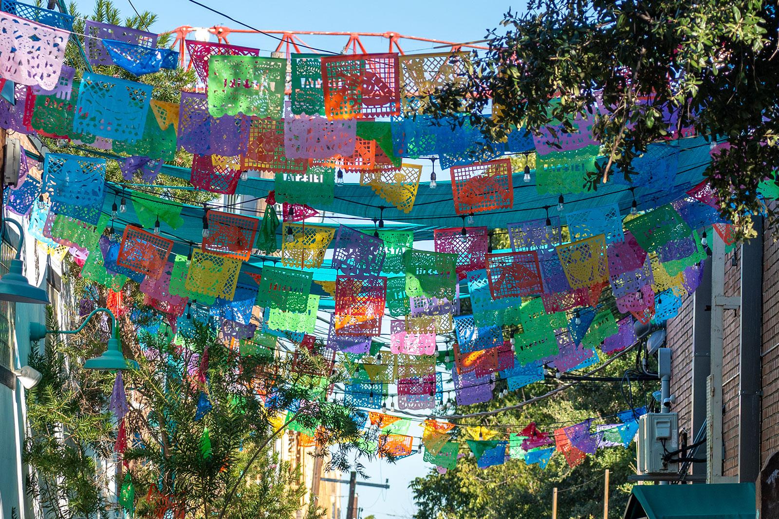 Mexican flags hang in a street.
