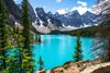Bright blue water surrounded by mountains and trees.