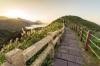 A brick walking trail with stone and wood railings leading over the mountains of Taipei.