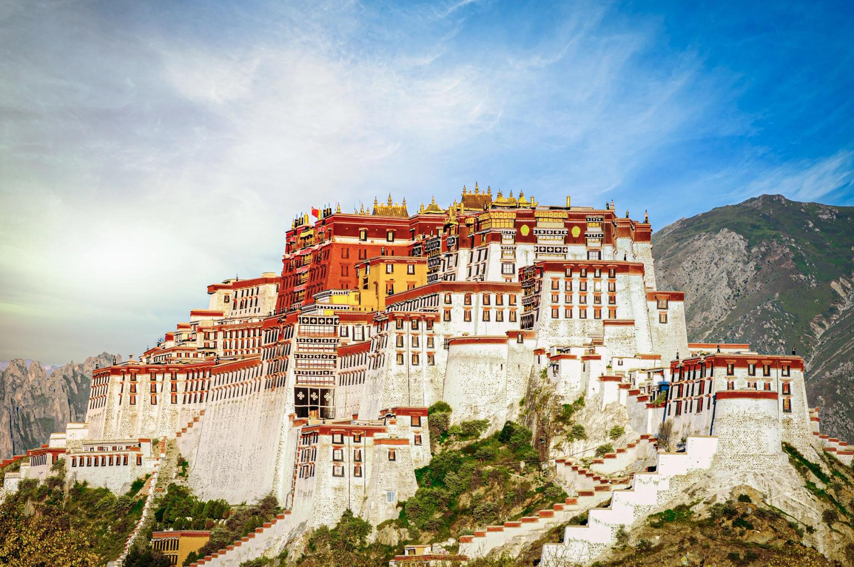 A vast palace with mountains behind it.