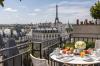 Breakfast on an outdoor terrace with a view over Paris including the Eiffel Tower.