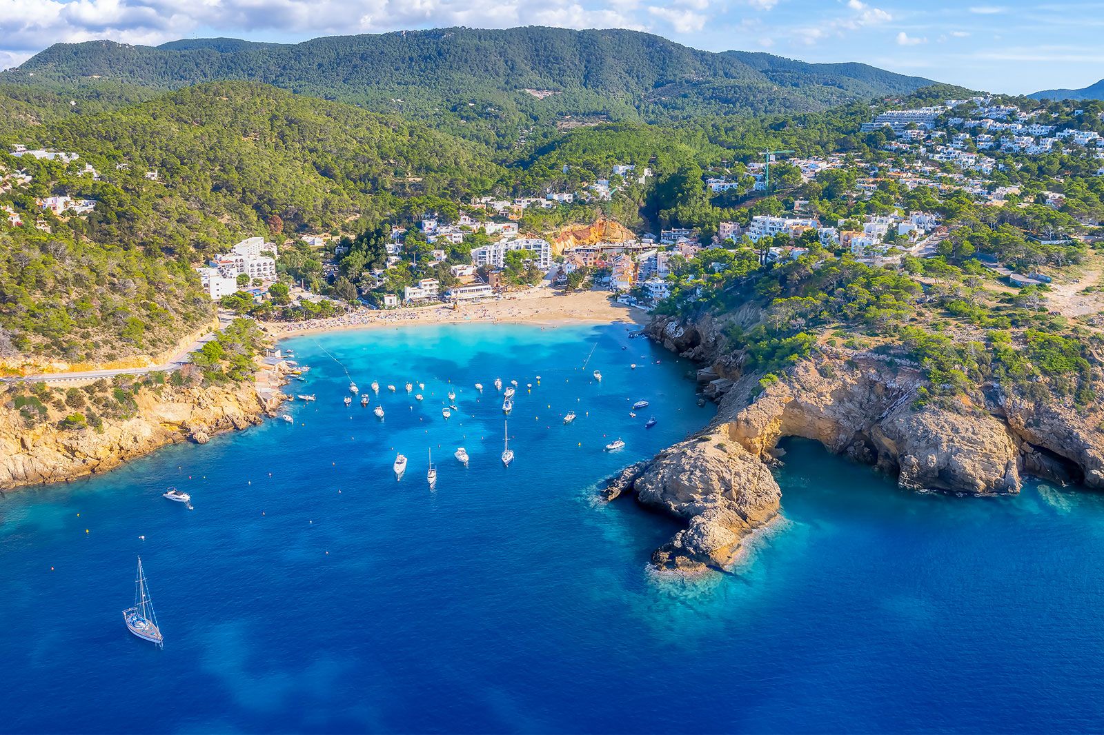 An aerial view of a rocky coastline with boats and beaches.