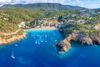 An aerial view of a rocky coastline with boats and beaches.