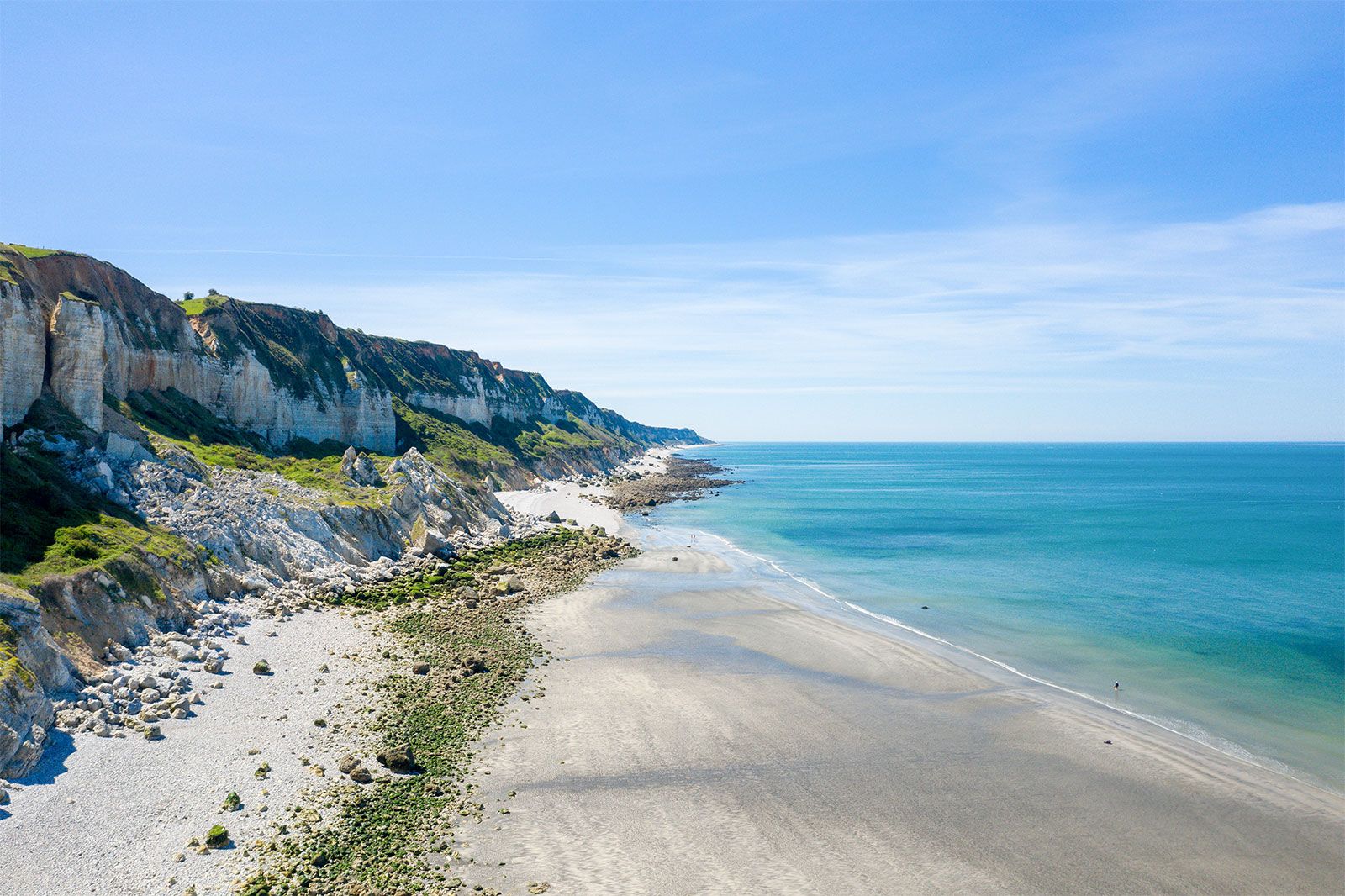 A cliff above the white pebbles. 