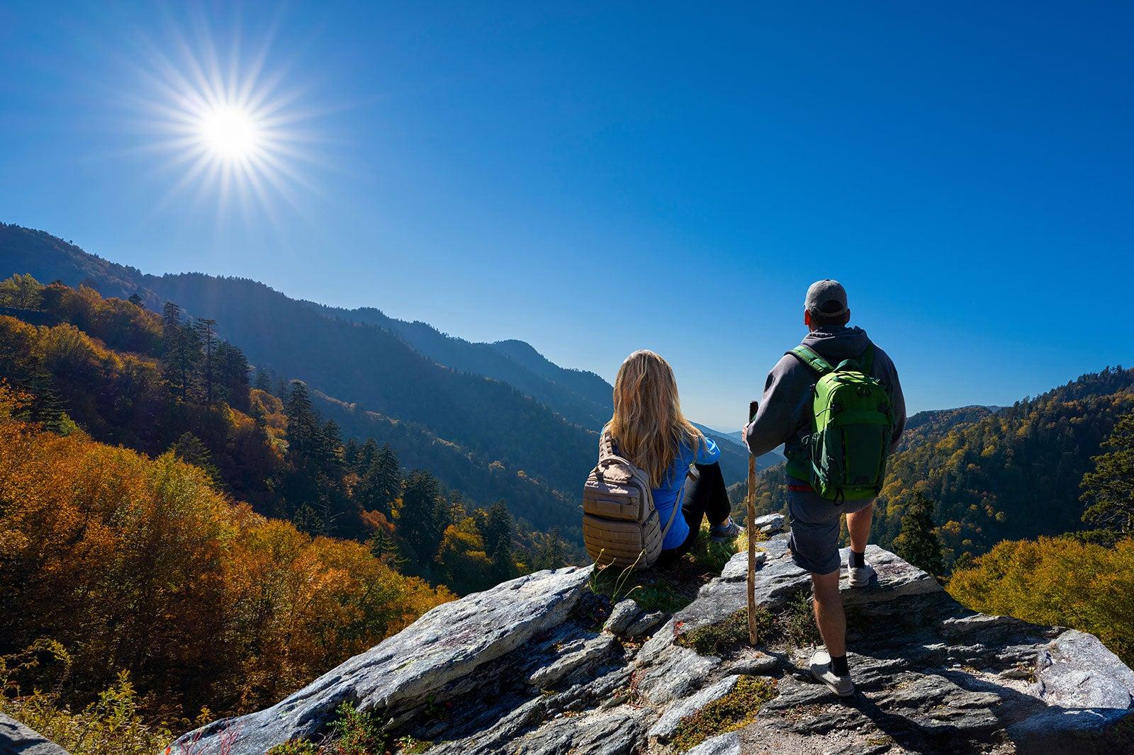 A man and woman on top of a mountain.