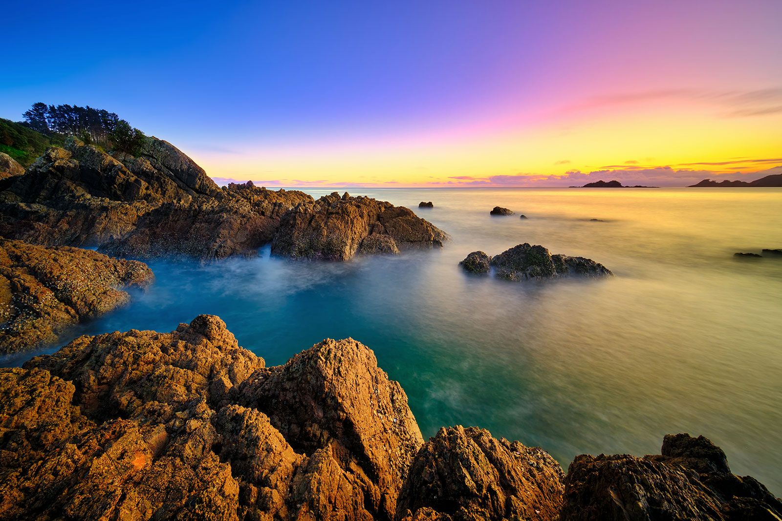 A sunrise on a rocky beach.