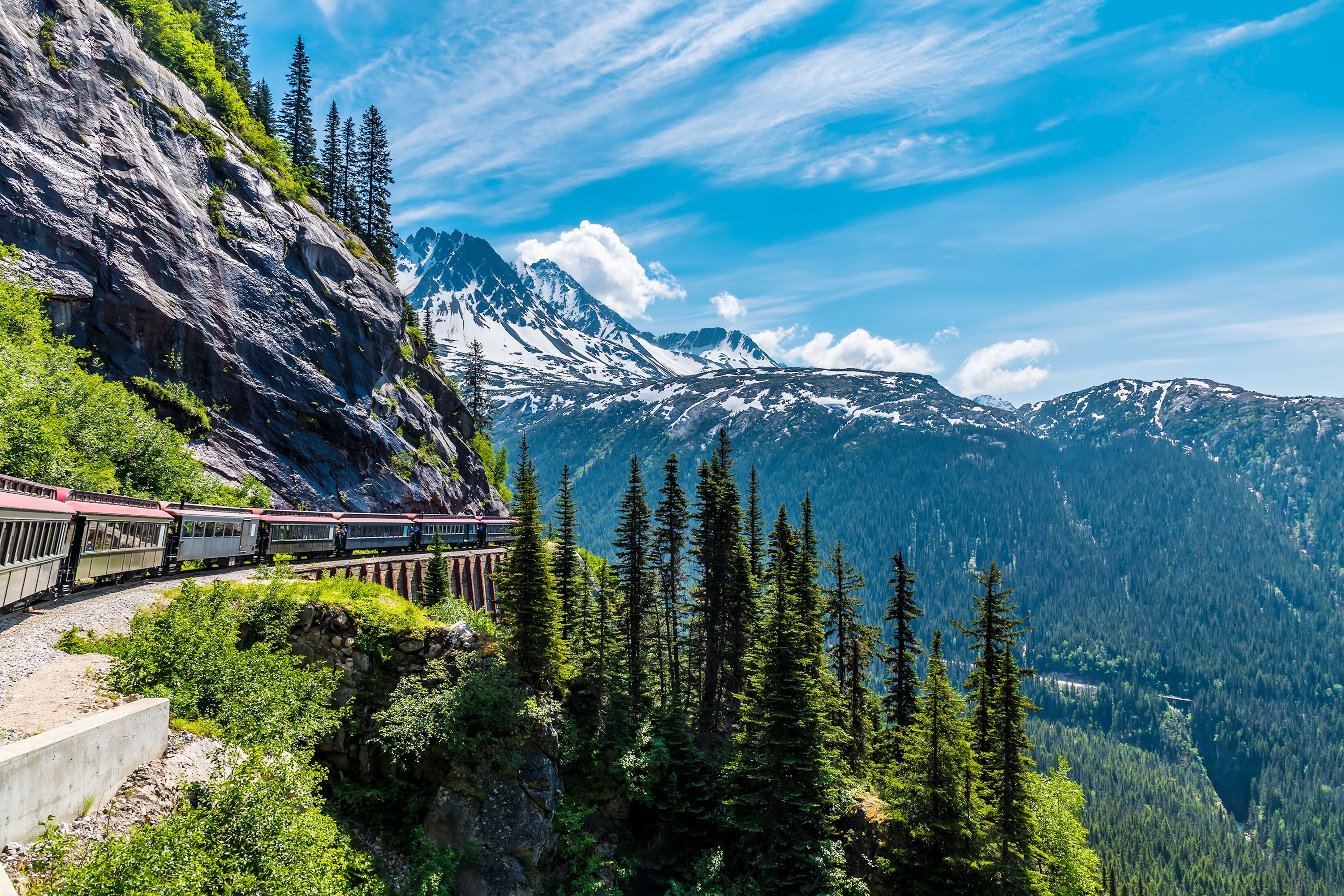 A view of the Yukon railway with a train on a bridge in Alaska.