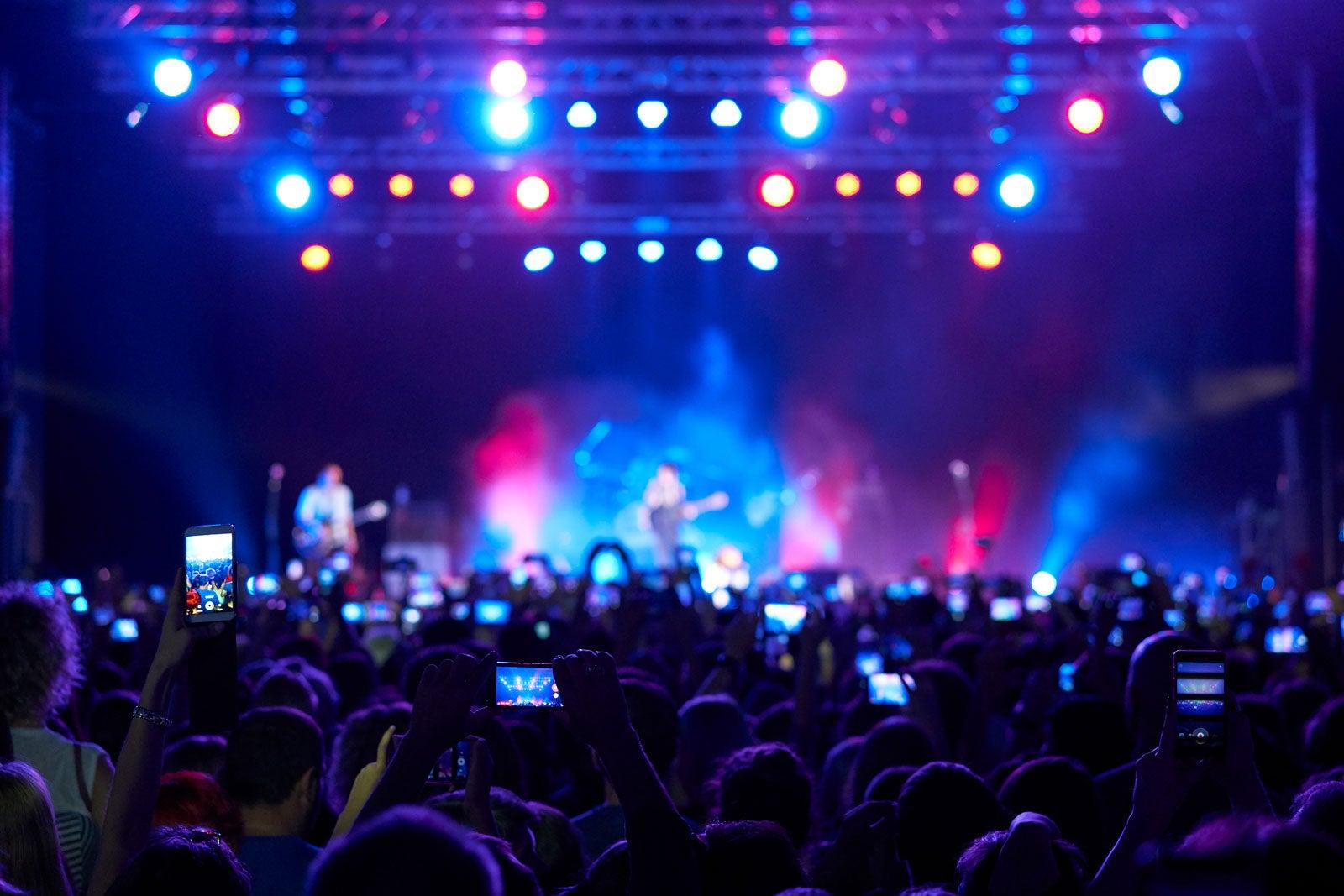 People with cameras recording a live performance.