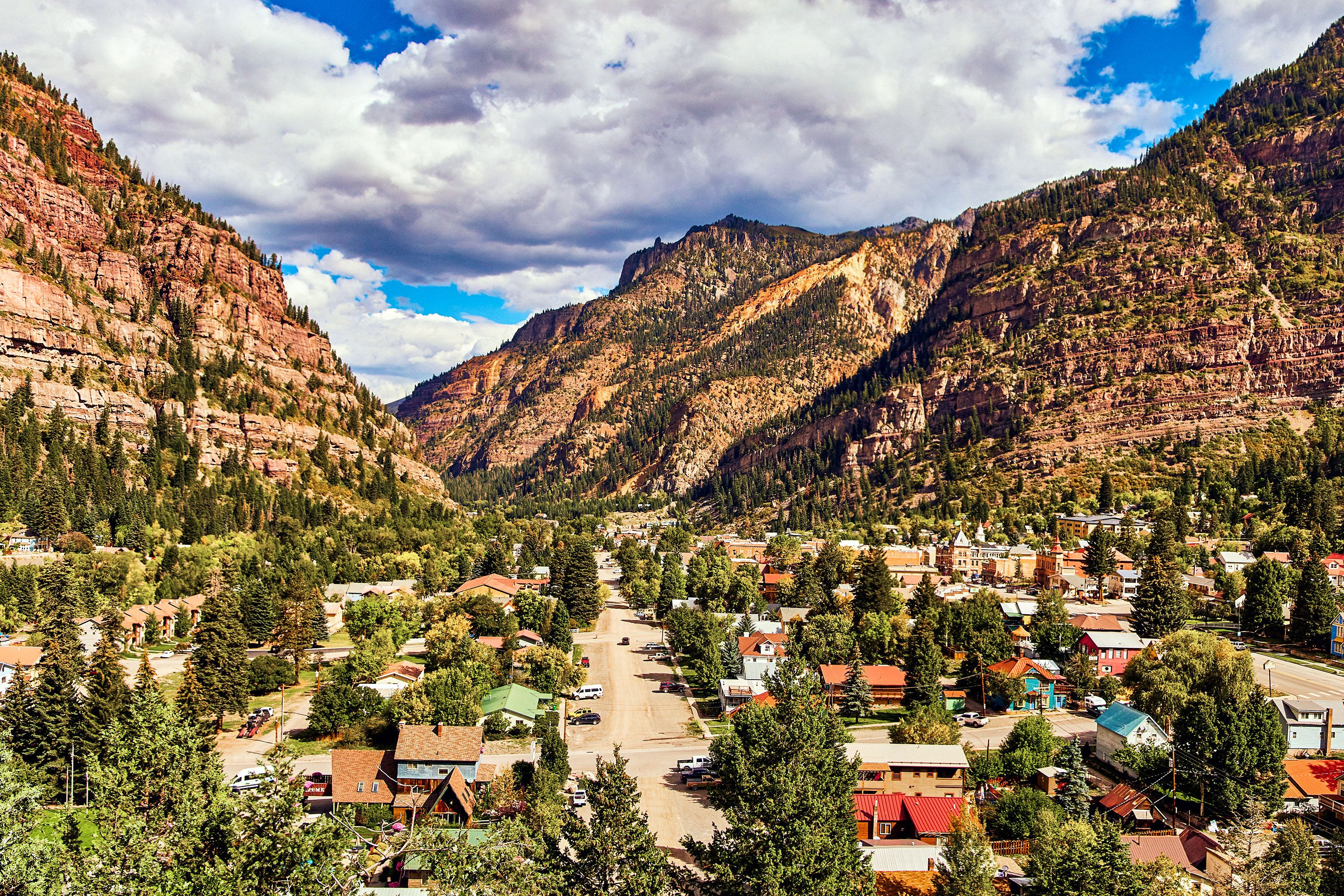 A view of Ouray mountain town buildings in Colorado nestled between mountains.