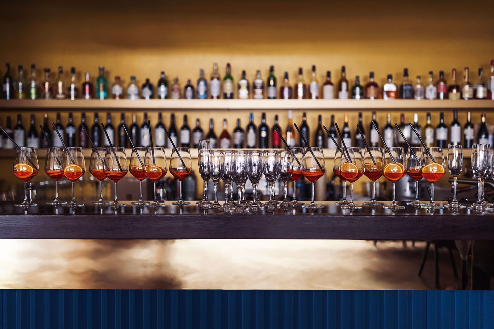 A night club with a bartender shelf with bottles of liquors.