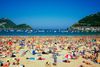 People relax on a sandy beach near the ocean.
