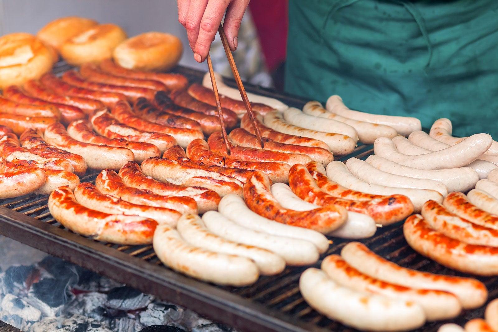 Rows of bratwurst on a large grill