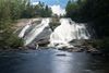 A large waterfall cascades down in a forest.
