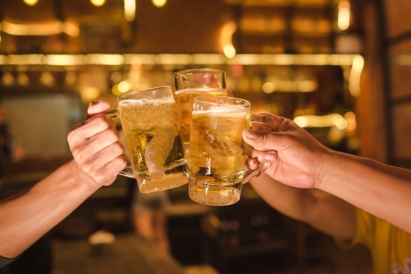 A close-up of three friends enjoying beers in a pub.