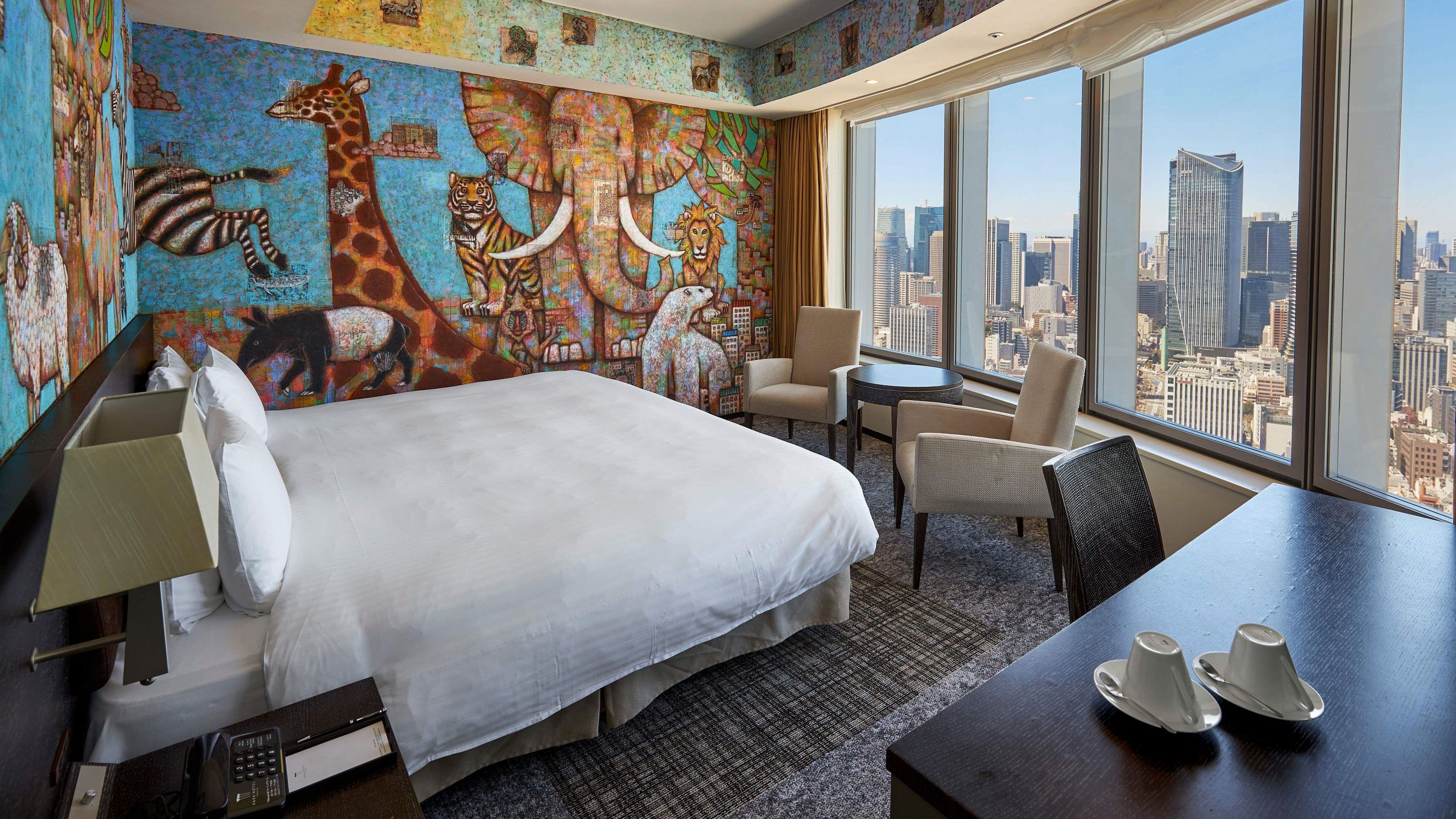A room with unique animal print walls with urban skyline view.