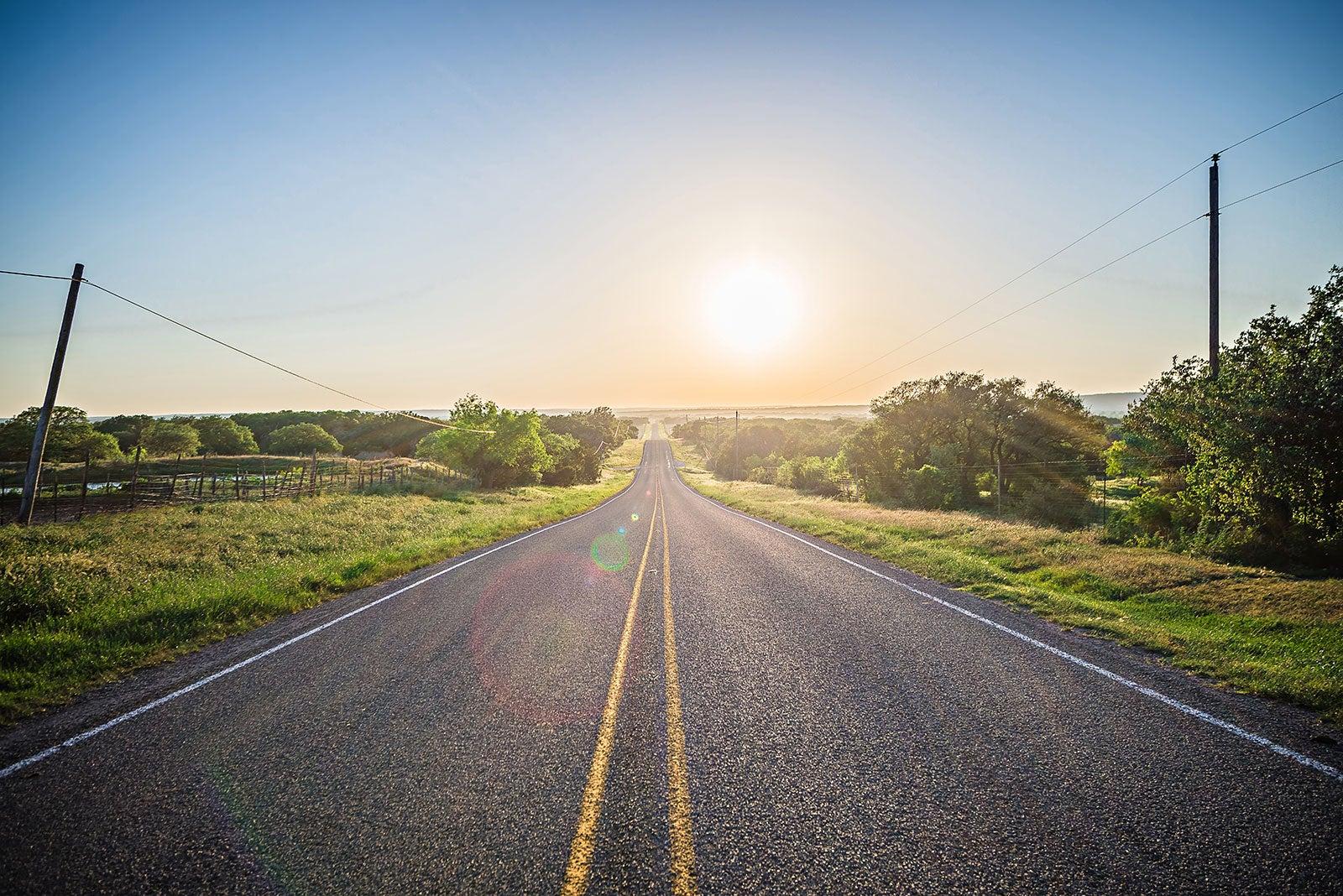 Open road with trees and power lines.