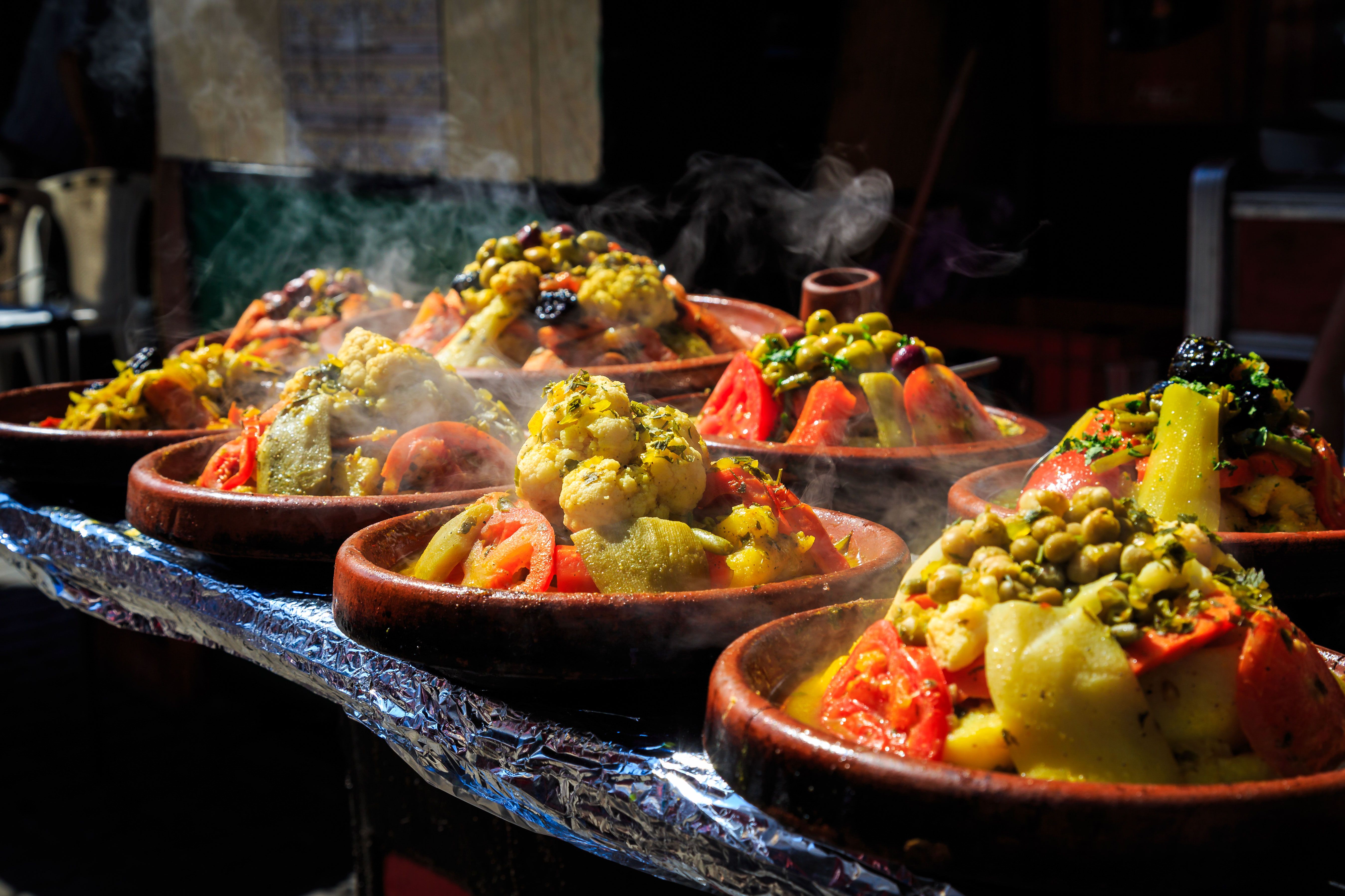 Hot plates steaming with food at a market.