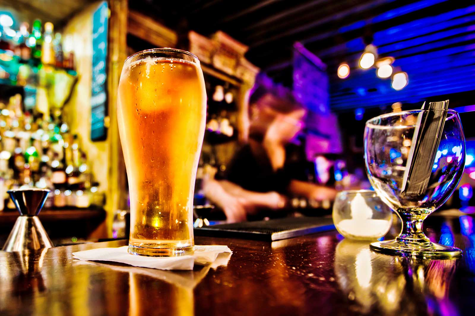 A pint of beer on top of a bar.