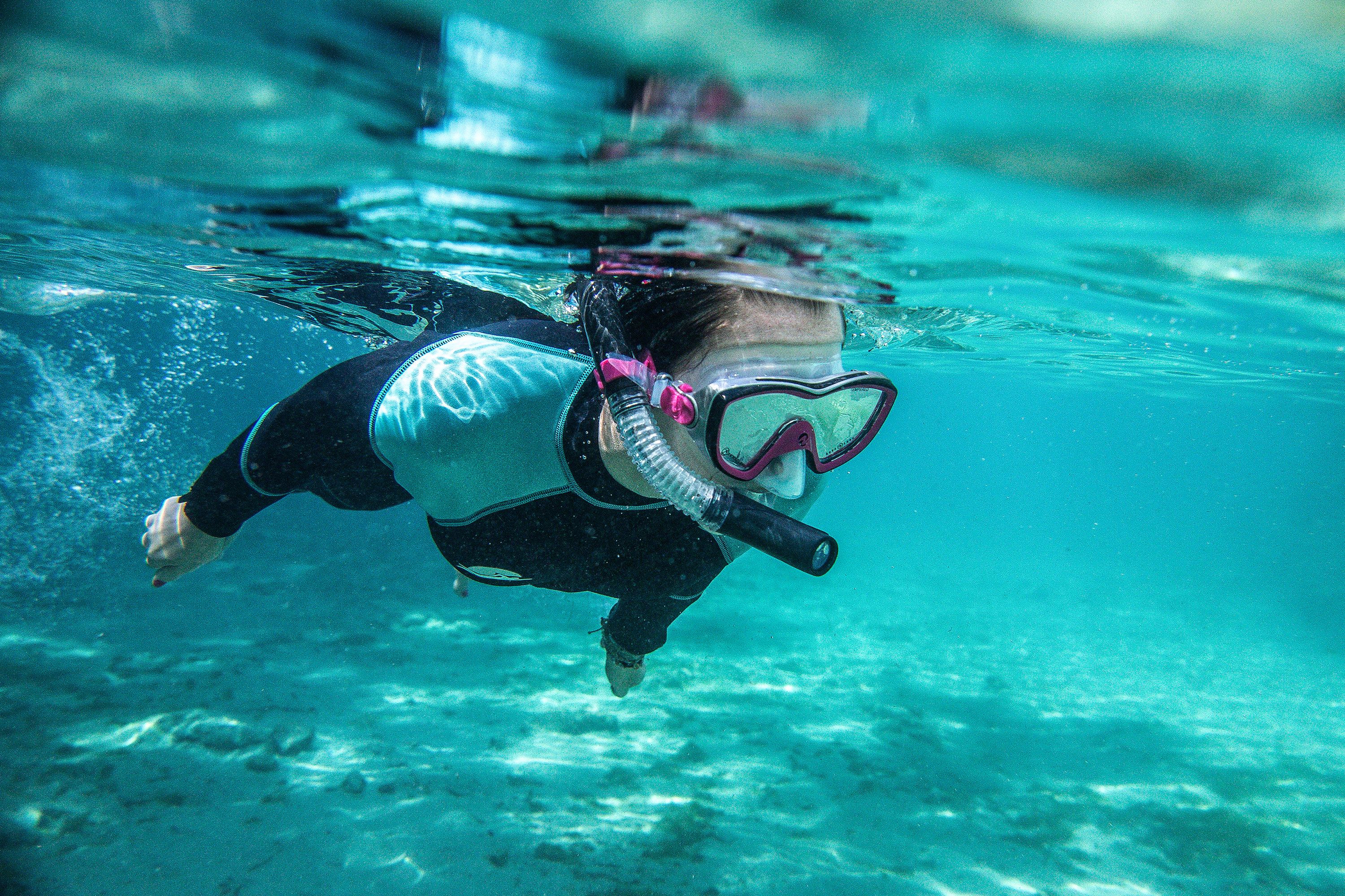 A kid snorkels underwater.