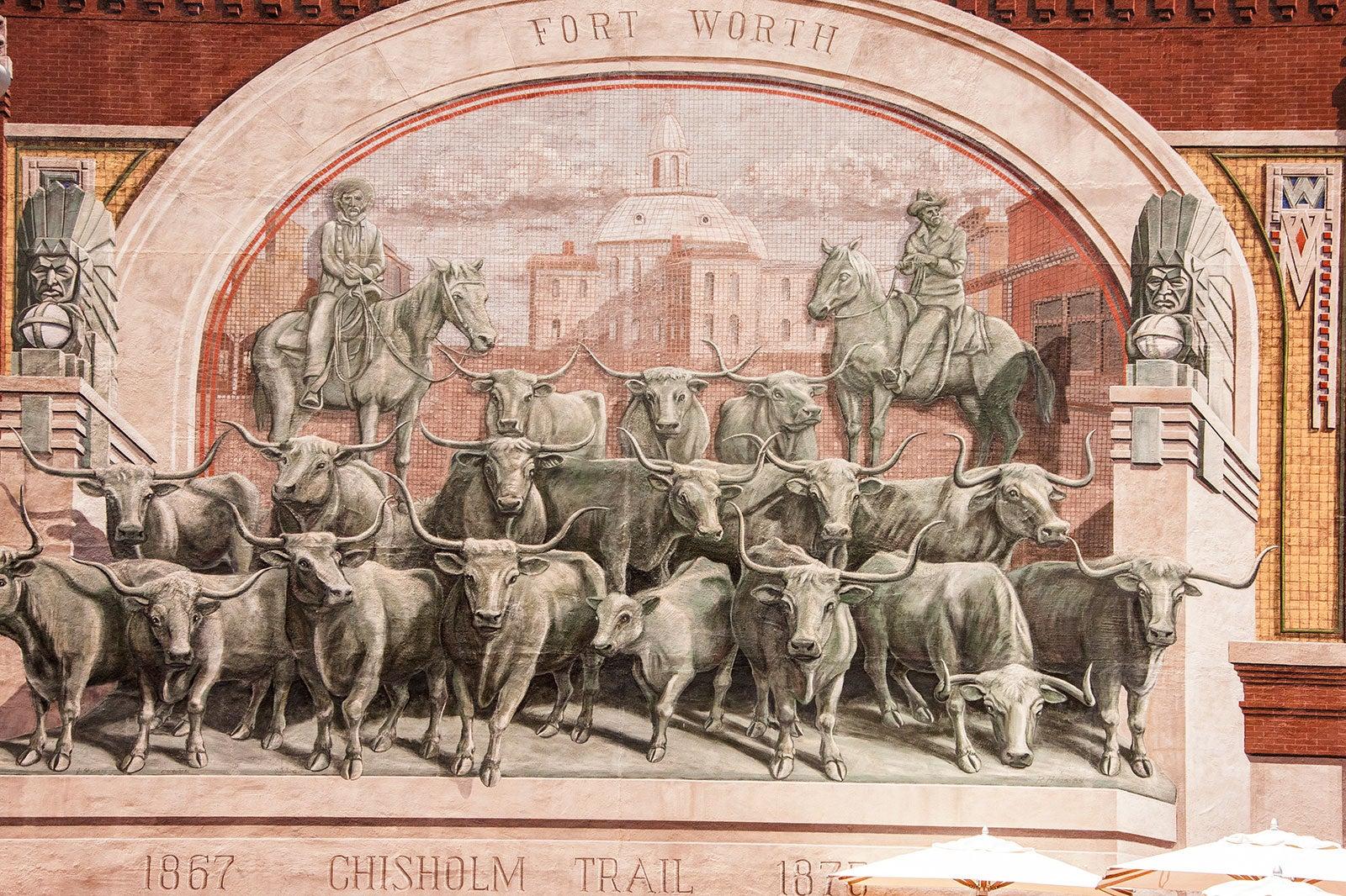 Sculpture of long horns and cowboys.