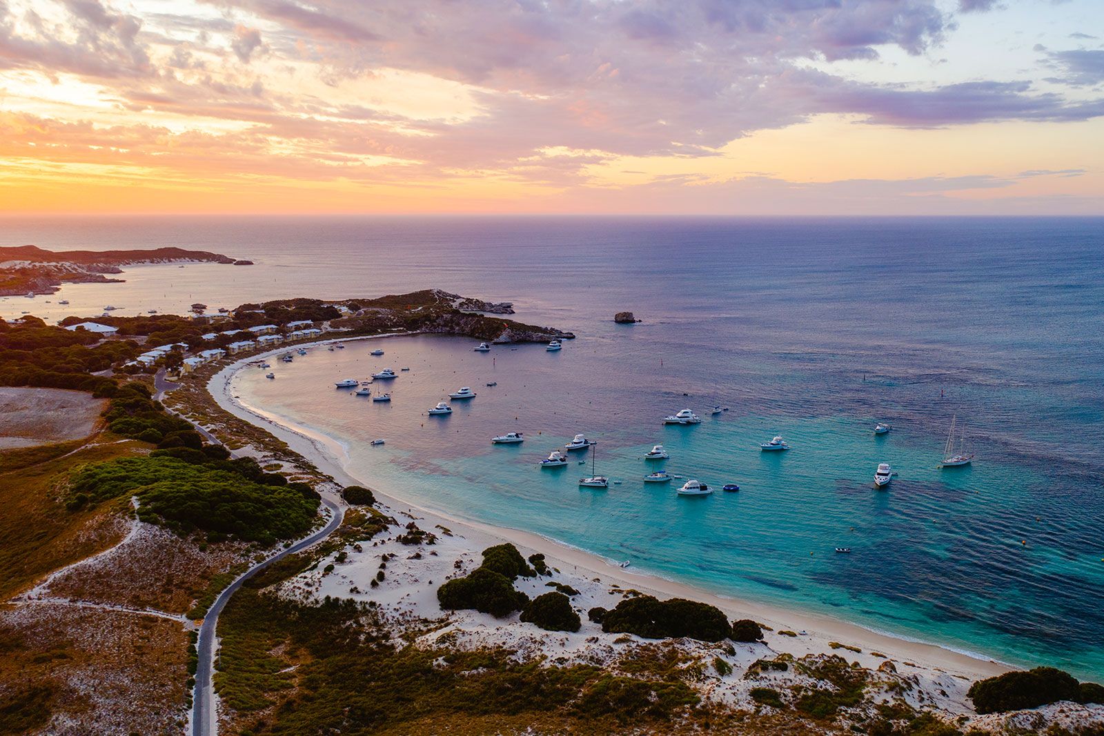 Beach with boats anchored in a bay.