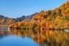 A lake with mountain covered in trees in autumn.