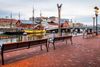 Boats on the water and benches.