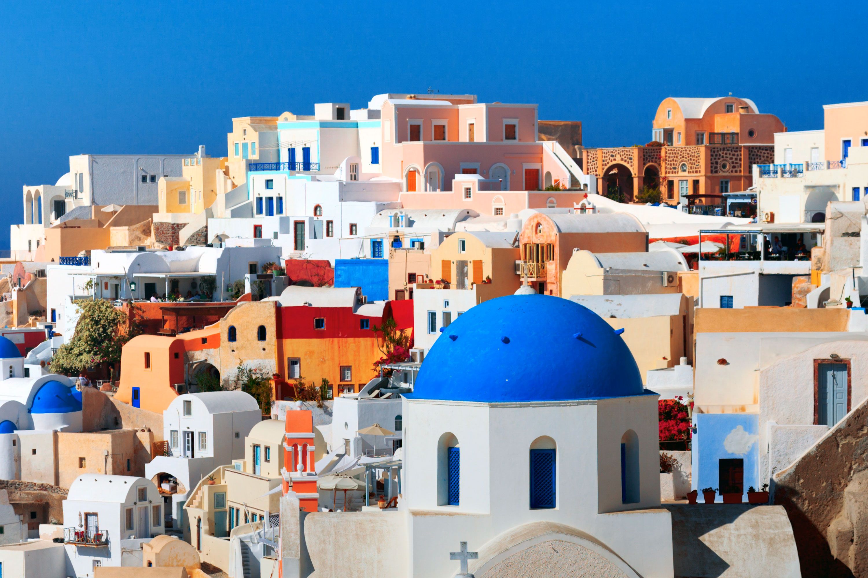 A view of colorful and white homes on a cliffside.