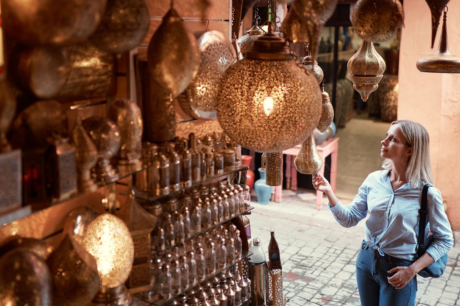 A person checking out Moroccan lamps at a market stall.