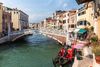 A view from a hotel room of a grand canal and bridge.