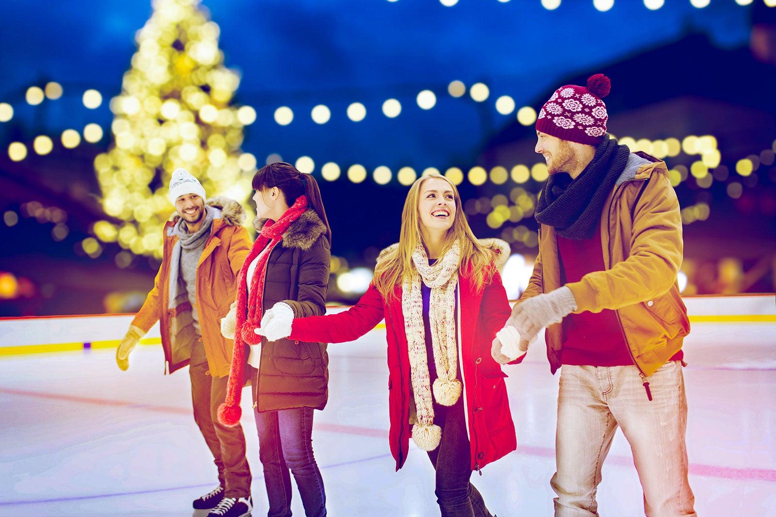 Couple skate on outdoor ice rink.